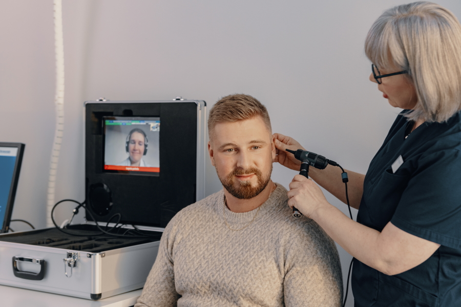 Kuvassa potilas ja hoitaja sekä lääkäri etäyhteyden päässä.